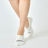 Model wearing white no-show socks, showcasing low-cut, snug fit around the heel and foot arch