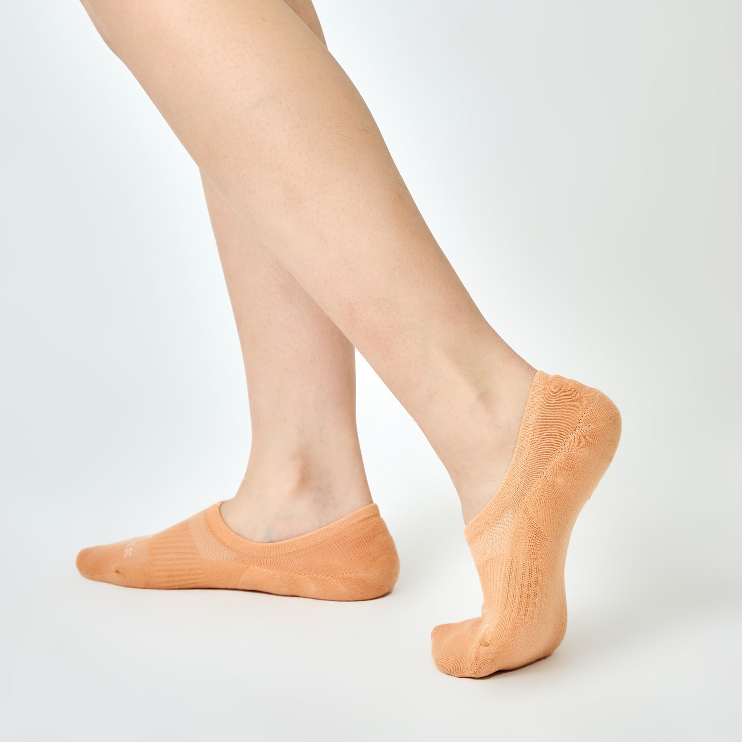 Side view of legs wearing orange no-show socks by Ohana Sunshine, highlighting low-cut fit and cushioned footbed design