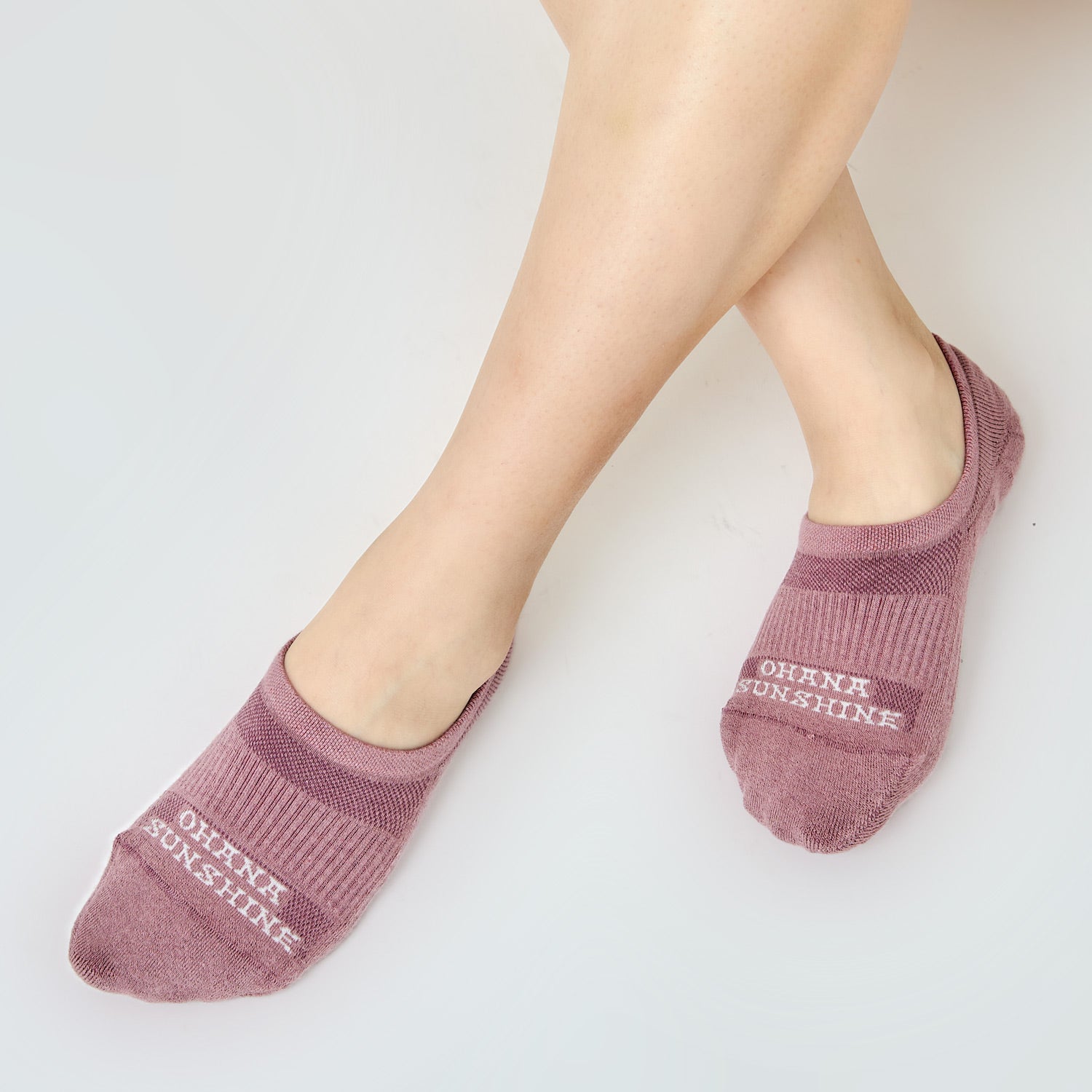 Model wearing purple no-show socks with “Ohana Sunshine” logo, showing moisture wicking mesh, arch design and snug fit over the foot